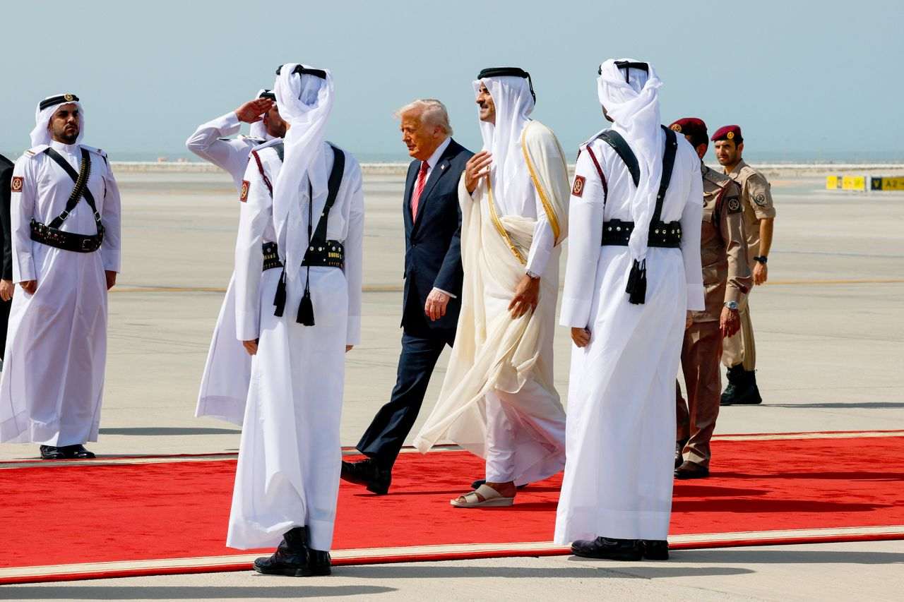 A group of men dressed in white suits and ties, standing together in a formal setting.